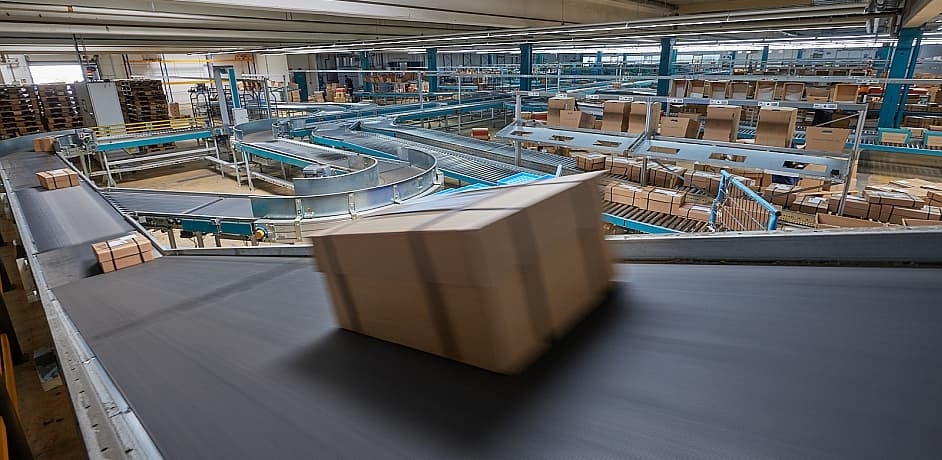 Warenpakete Aktionspakete für Buchhandlungen Ein Paket auf einem Förberband als Symbol für Aktionspakete